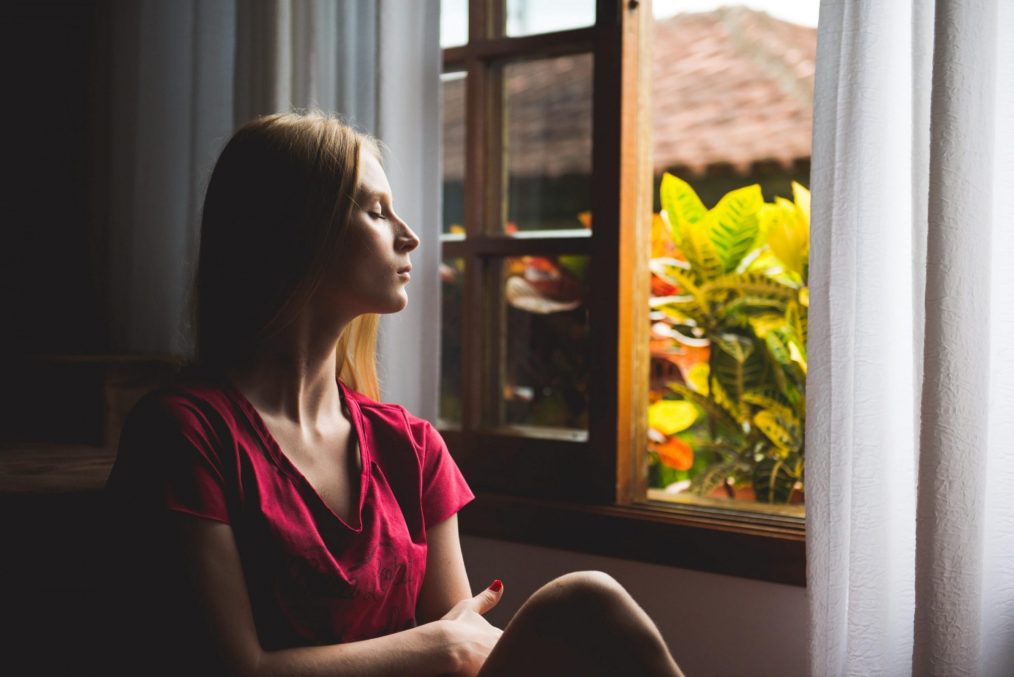 אישה בבידוד מביטה מהחלון