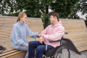 אדם בכיסא גלגלים משוחח עם אישה